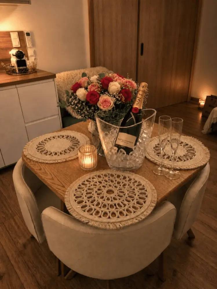 Table avec bouquet de roses et bouteille de Champagne